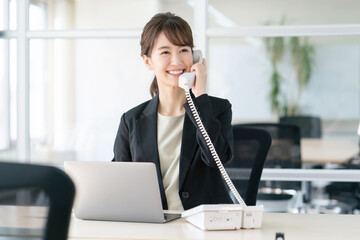 笑顔で電話対応をする女性スタッフの写真