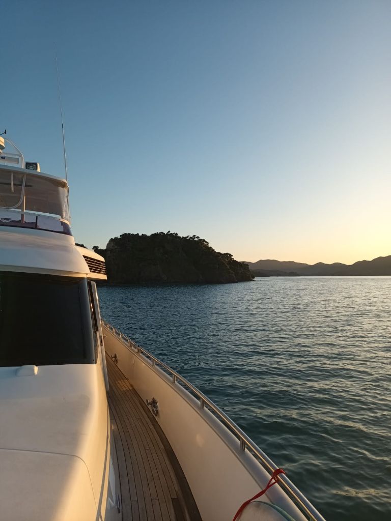 Luxury yacht at sunset with coastal scenery