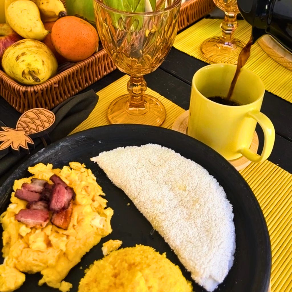 Café da manhã servido na varanda com frutas tropicais e tapioca