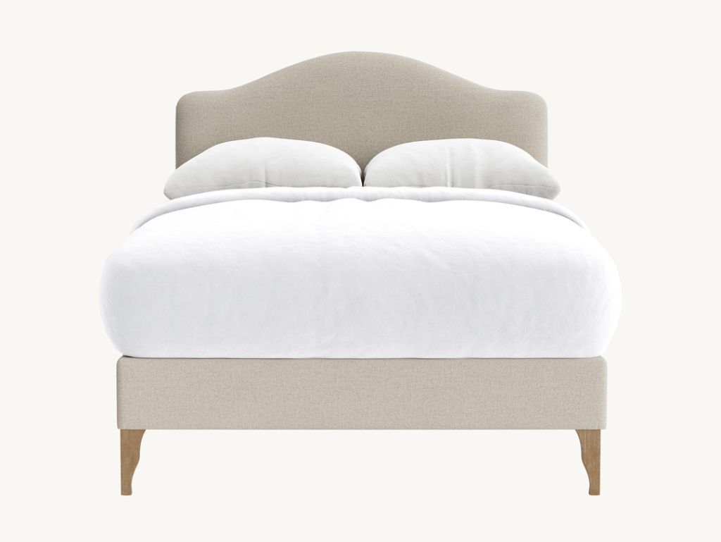 Rounded headboard bed with plush white bedding