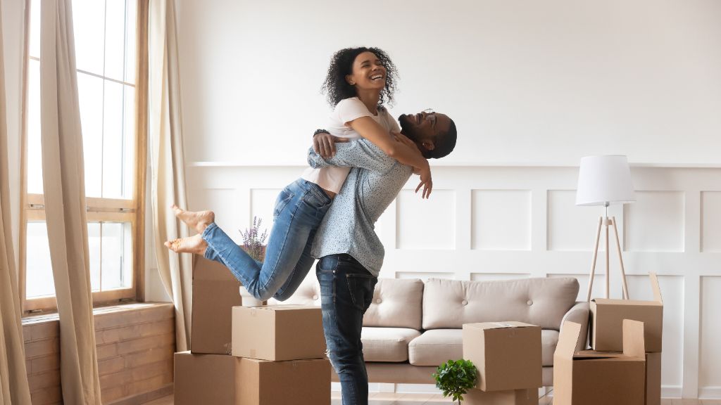 Couple celebrating move-in day in new living room