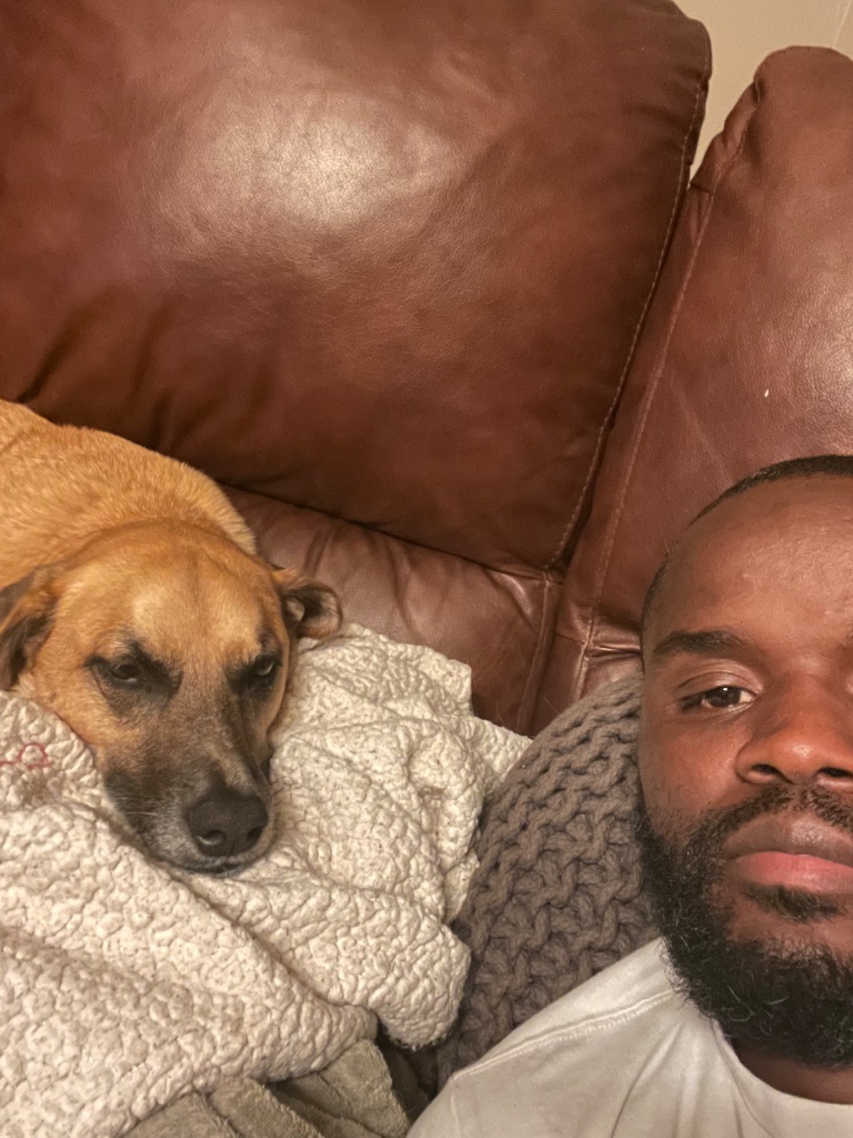 Shawn relaxing with a dog at home, showing his calm and caring nature