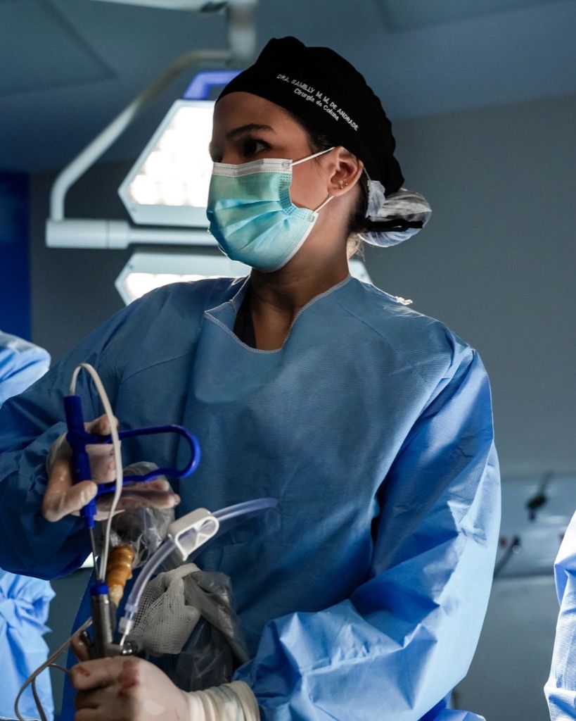 Cirurgiã realizando endoscopia da coluna vertebral - procedimento minimamente invasivo