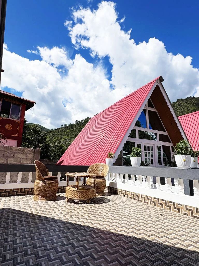 A-frame cottages with red roofs amid mountain scenery