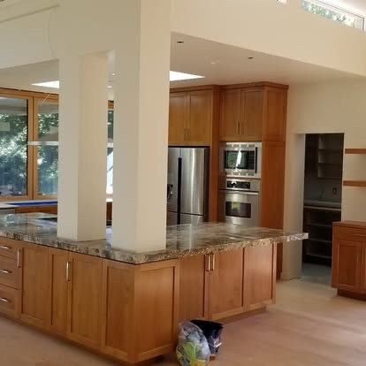 Modern luxury kitchen renovation with custom walnut cabinets and marble countertops