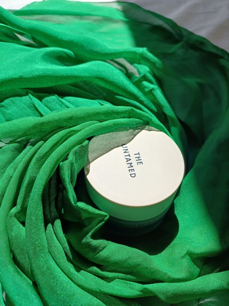 The Untamed Product on Green Fabric