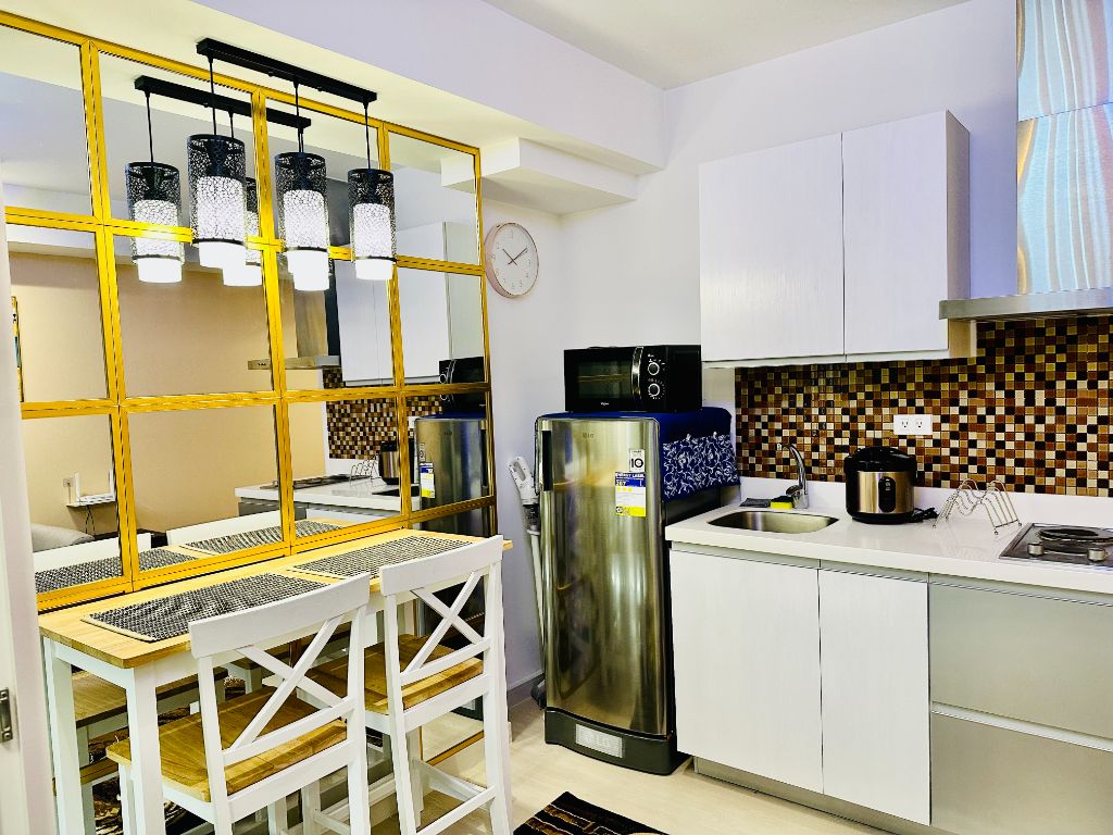 Azure Urban Resort modern kitchen with golden shelving and mosaic backsplash