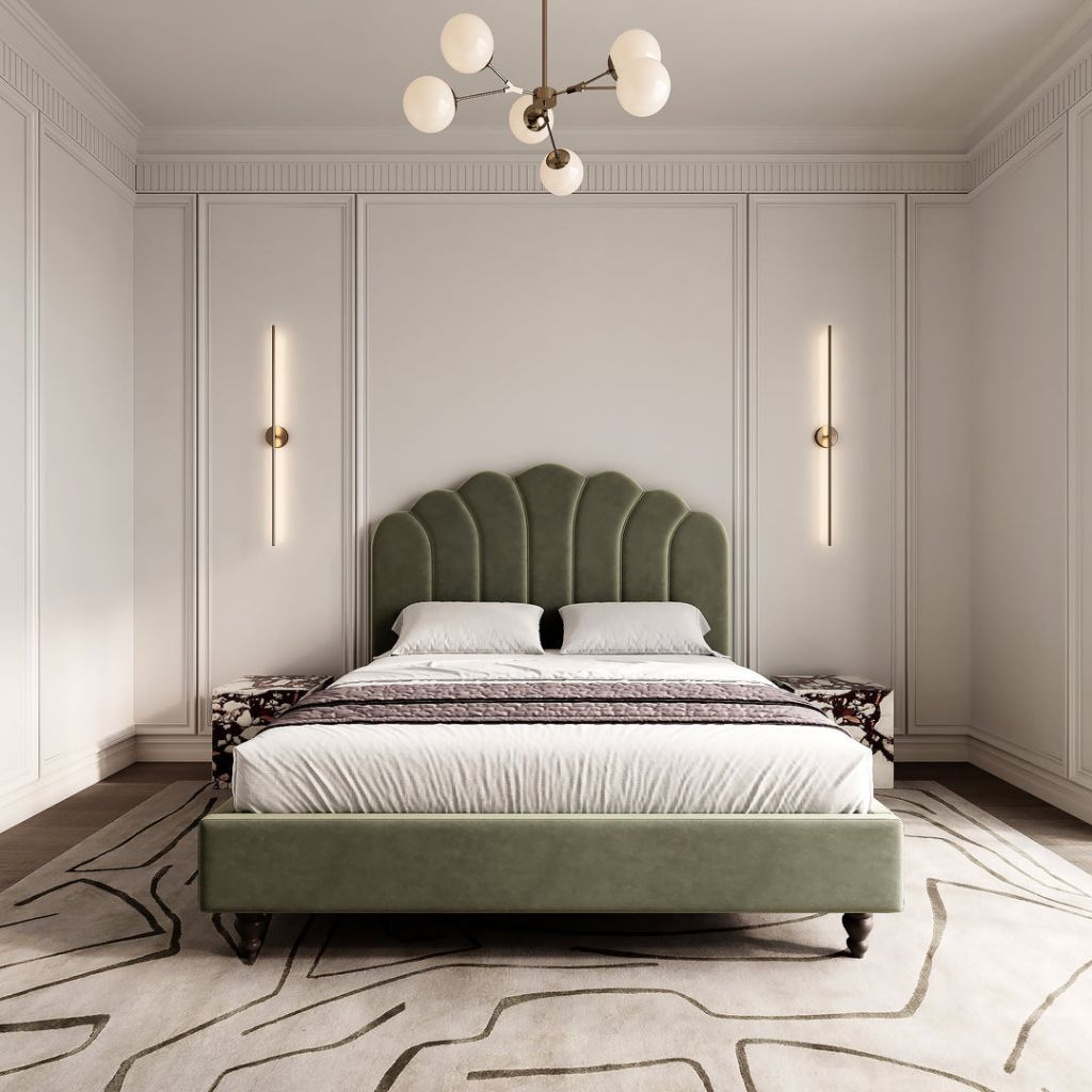 Sage velvet bed framed by fluted wall sconces and layered marble tables