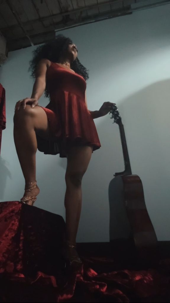 Sapphyre Bardot in red dress with guitar