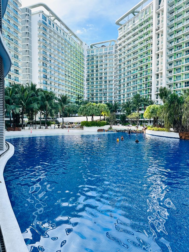 Azure Urban Resort wave pool with towering residential buildings and tropical setting