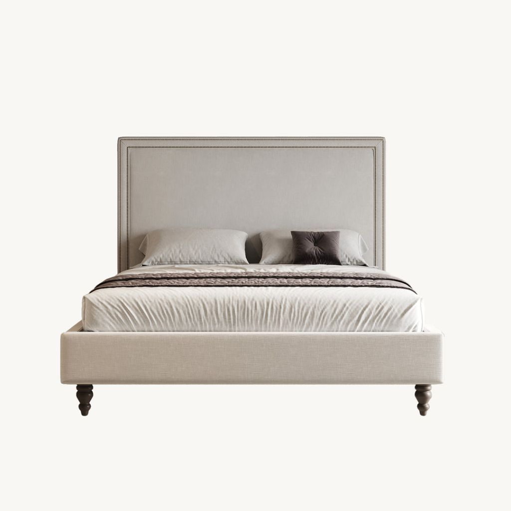 Tailored upholstered bed with turned legs and crisp bedding