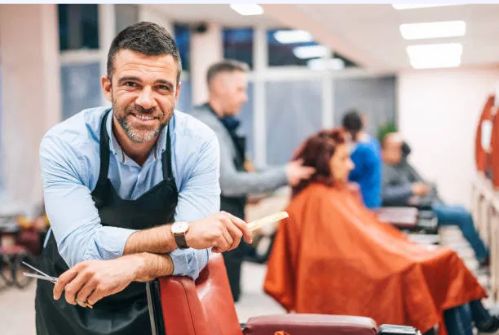 Happy local business owner working in his salon, representing small businesses that benefit from AI employees
