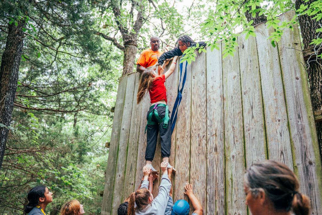Participants working together to overcome challenges, demonstrating the spirit of community support and mutual aid that defines CJAMM's transformational approach