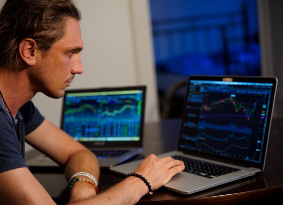 Trader arbeitet mit mehreren Trading-Bildschirmen