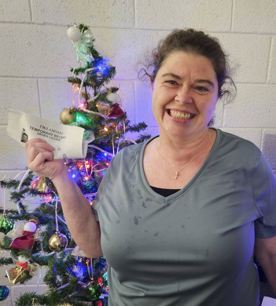 Woman celebrating receiving her driver's license during holiday season through criminal justice support