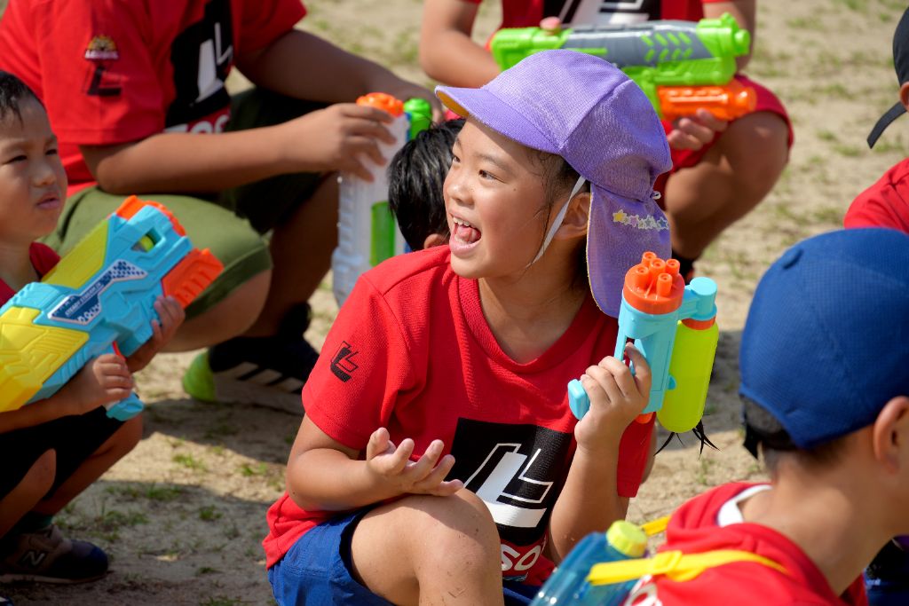 水鉄砲大会 - カラフルな水鉄砲を持って笑顔の子どもたち